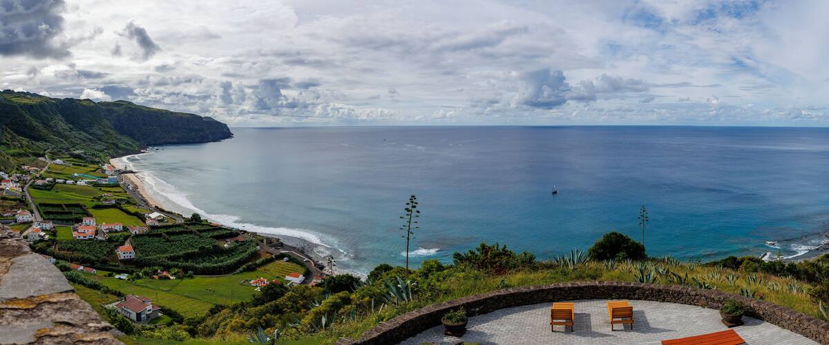 A coastal village with houses, a beach, and a view of the ocean.