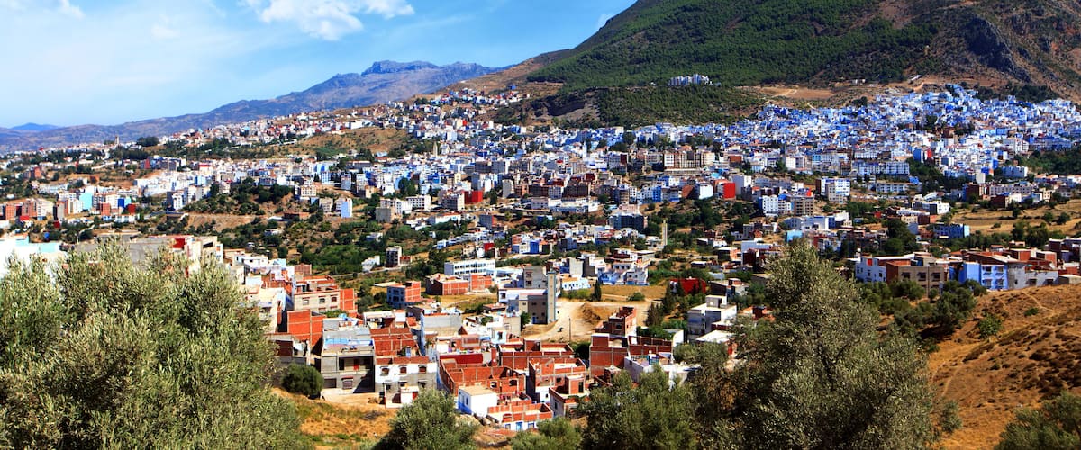 A town nestled in a valley with a mountain in the background.