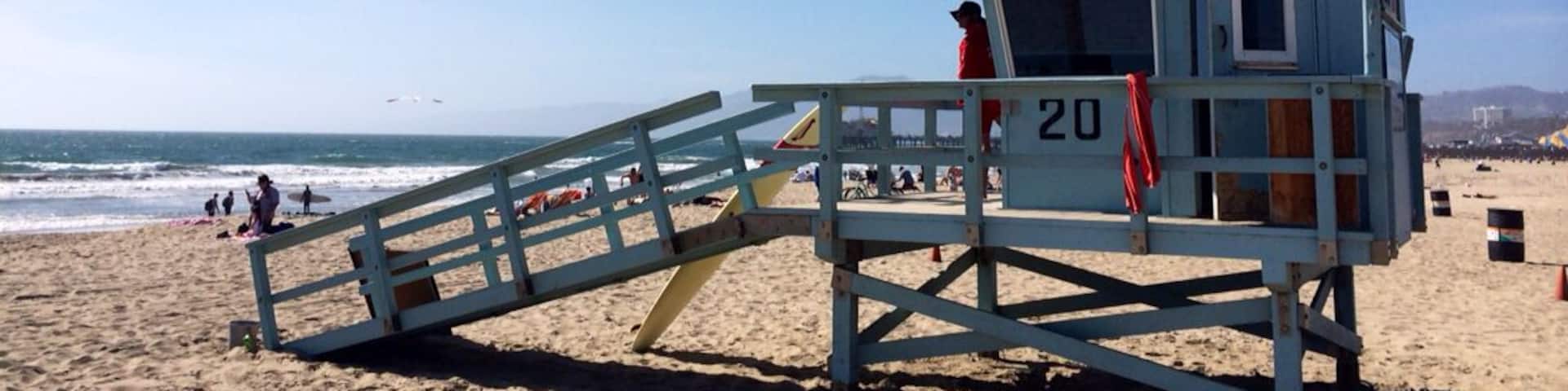 A lifeguard tower with an American flag on a beach.