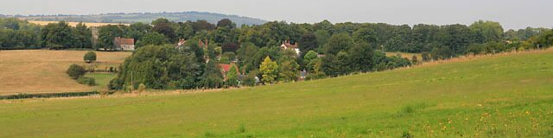 View of Soberton village from Chalk Hill. This is taken from the top of the road triangle at the southern end of Chalk Hill. St Peter's church can be seen at left. The white building is the White Lion pub (I think).