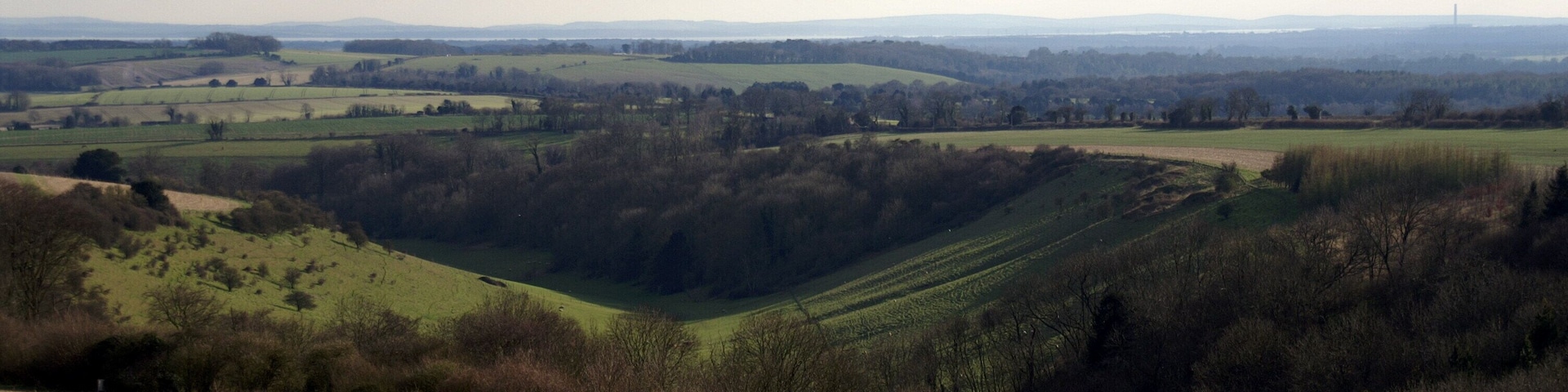 Des collines ondulantes, des champs et une tour qui se dresse au loin.