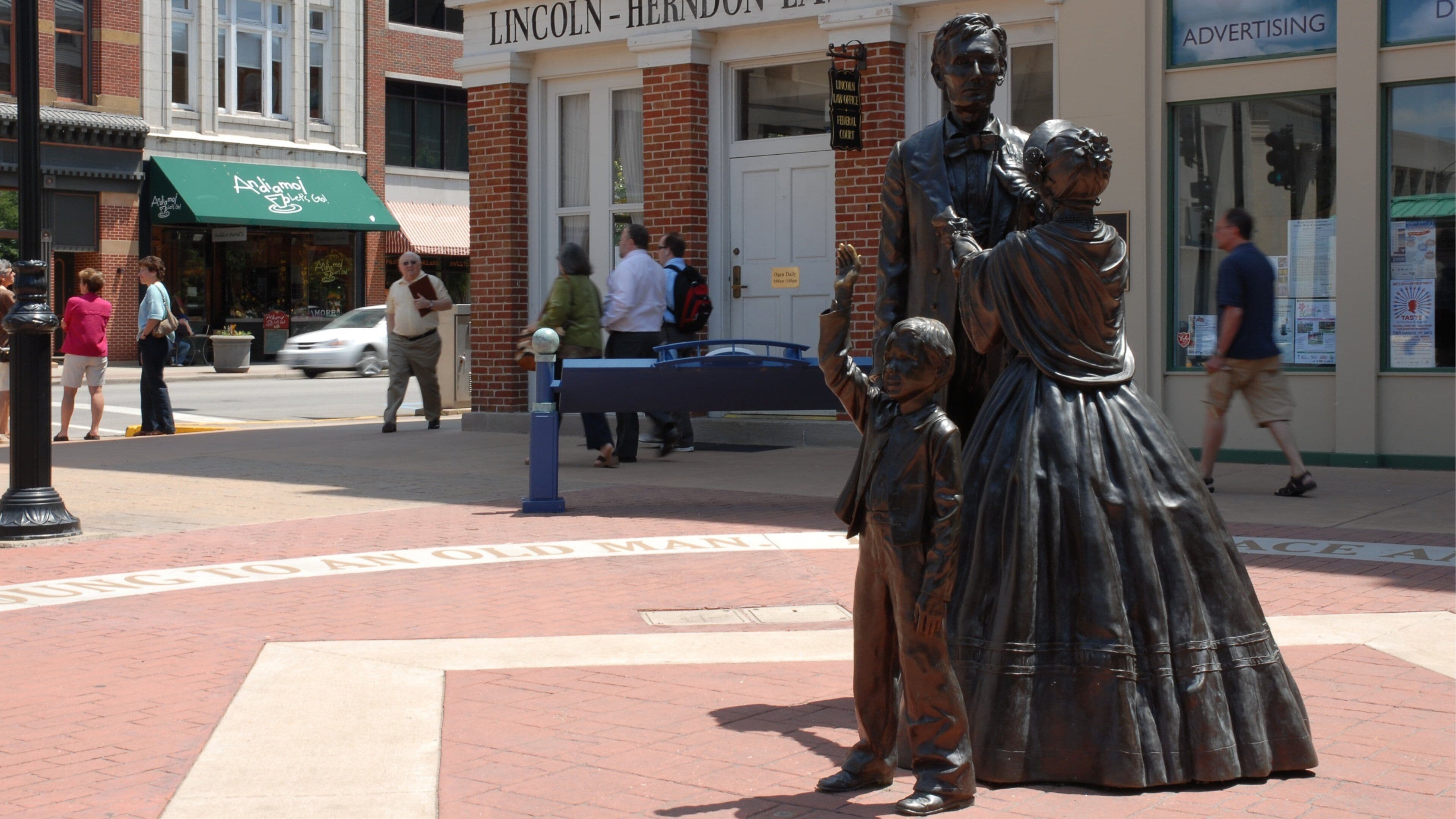 A bronze statue of a man and woman with a child in front of a building labeled "Lincoln-Herndon Law Office."