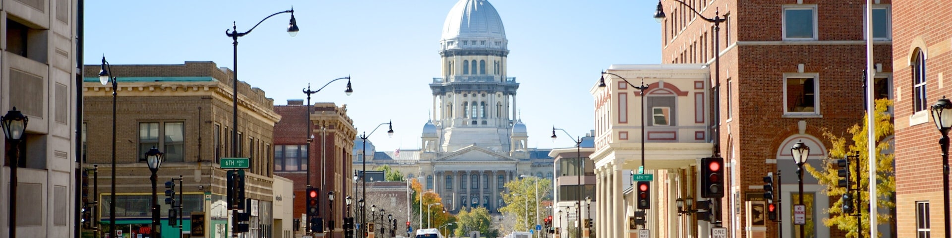 A city street with a large white dome building in the background.