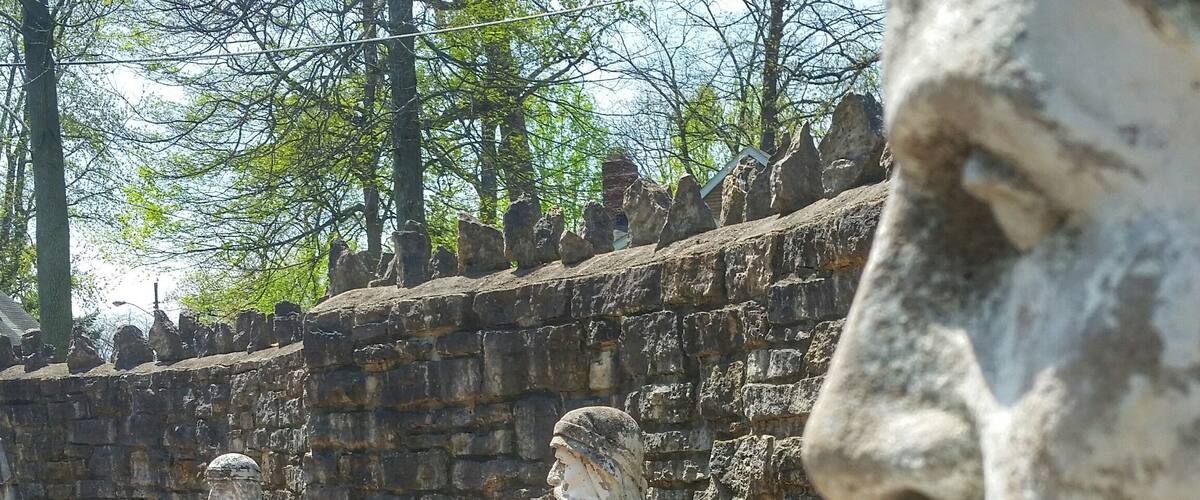 Stone statues and a brick wall.