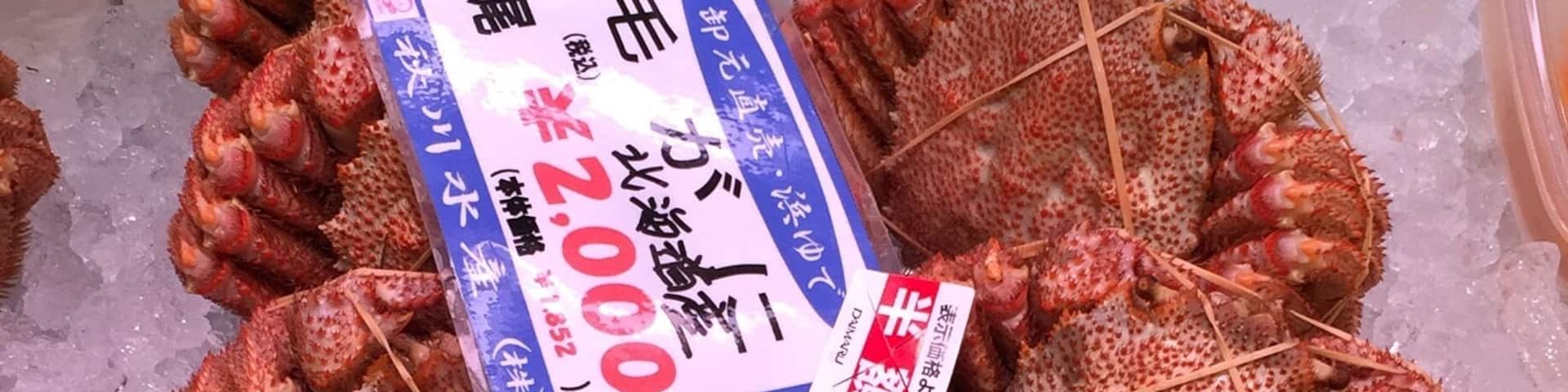 A display of seafood, specifically crayfish, on ice with a price tag.