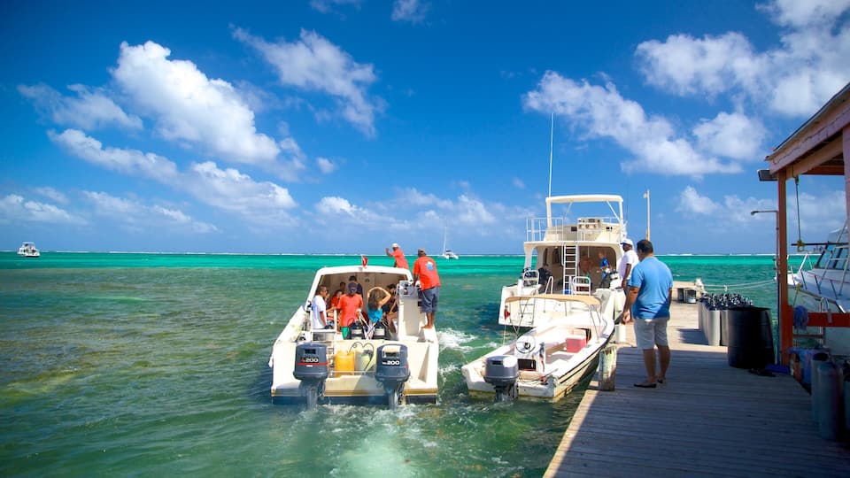 A boat docked at a pier with clear turquoise water and a bright blue sky.