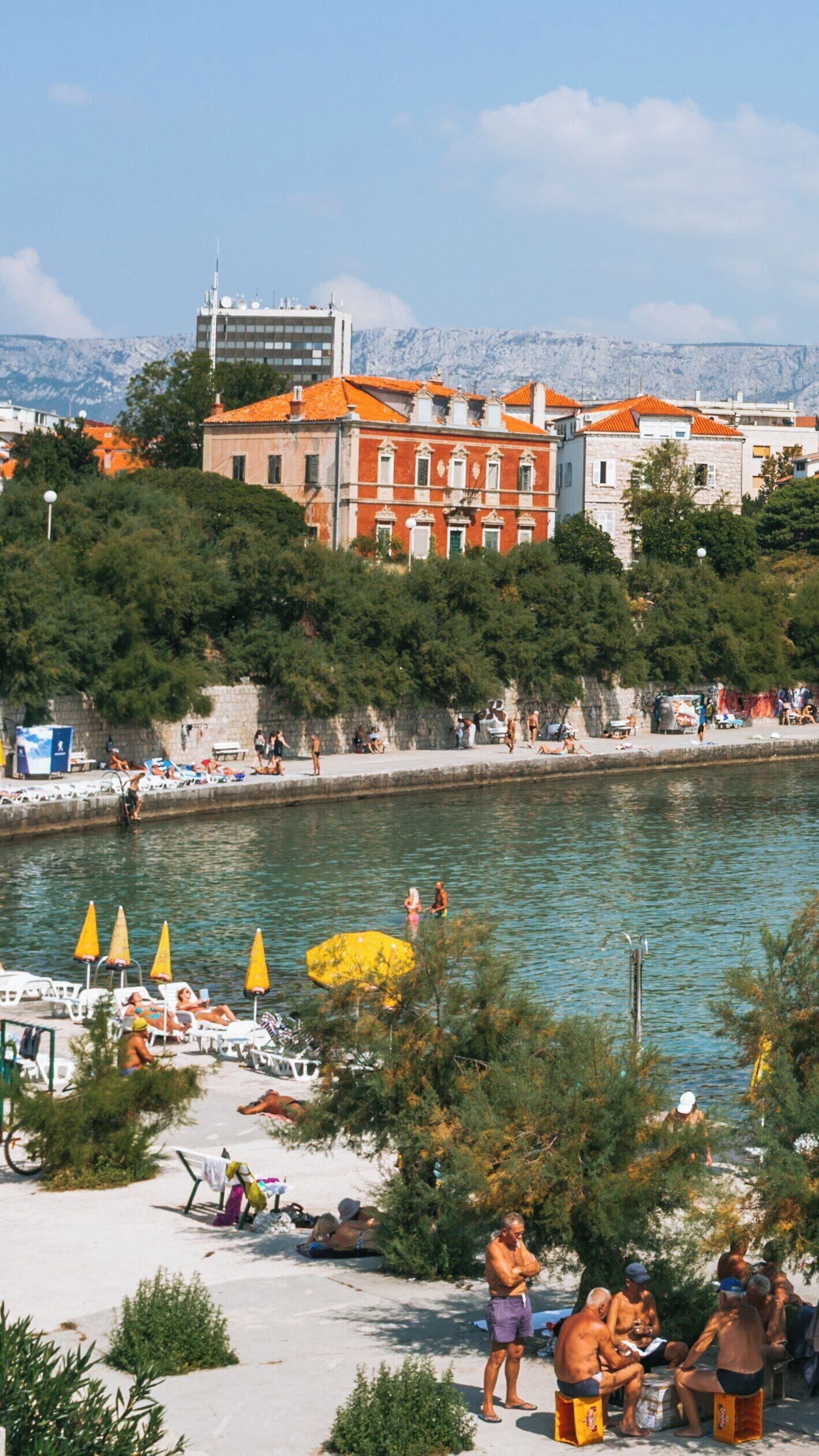 Charming Bacvice Beach in Split, Croatia with Sunbathers, Clear Water, and Vibrant Surroundings on a Sunny Day