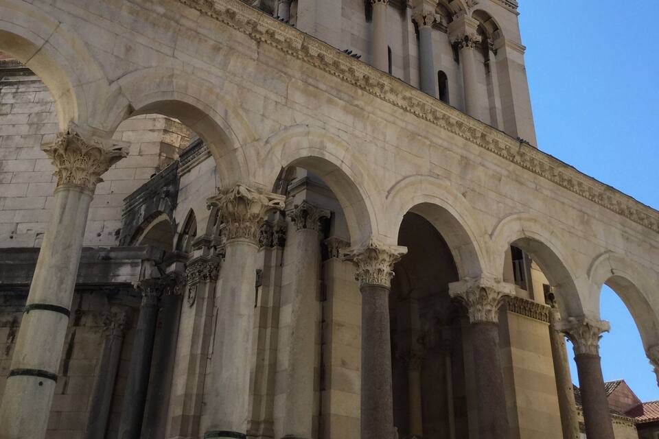 A tall, ornate tower with intricate architectural details and a clear blue sky in the background.
