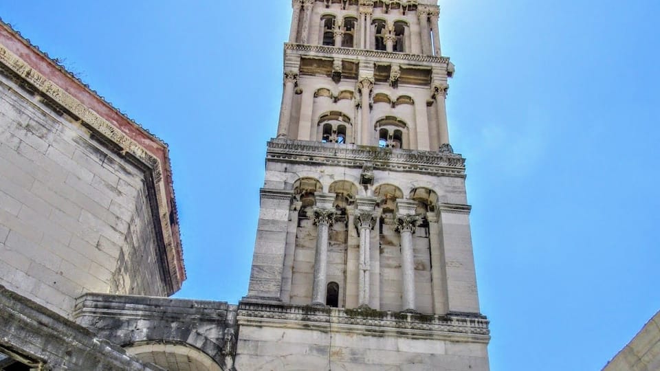 A tall, ornate tower with multiple arches and columns, surrounded by classical architecture.