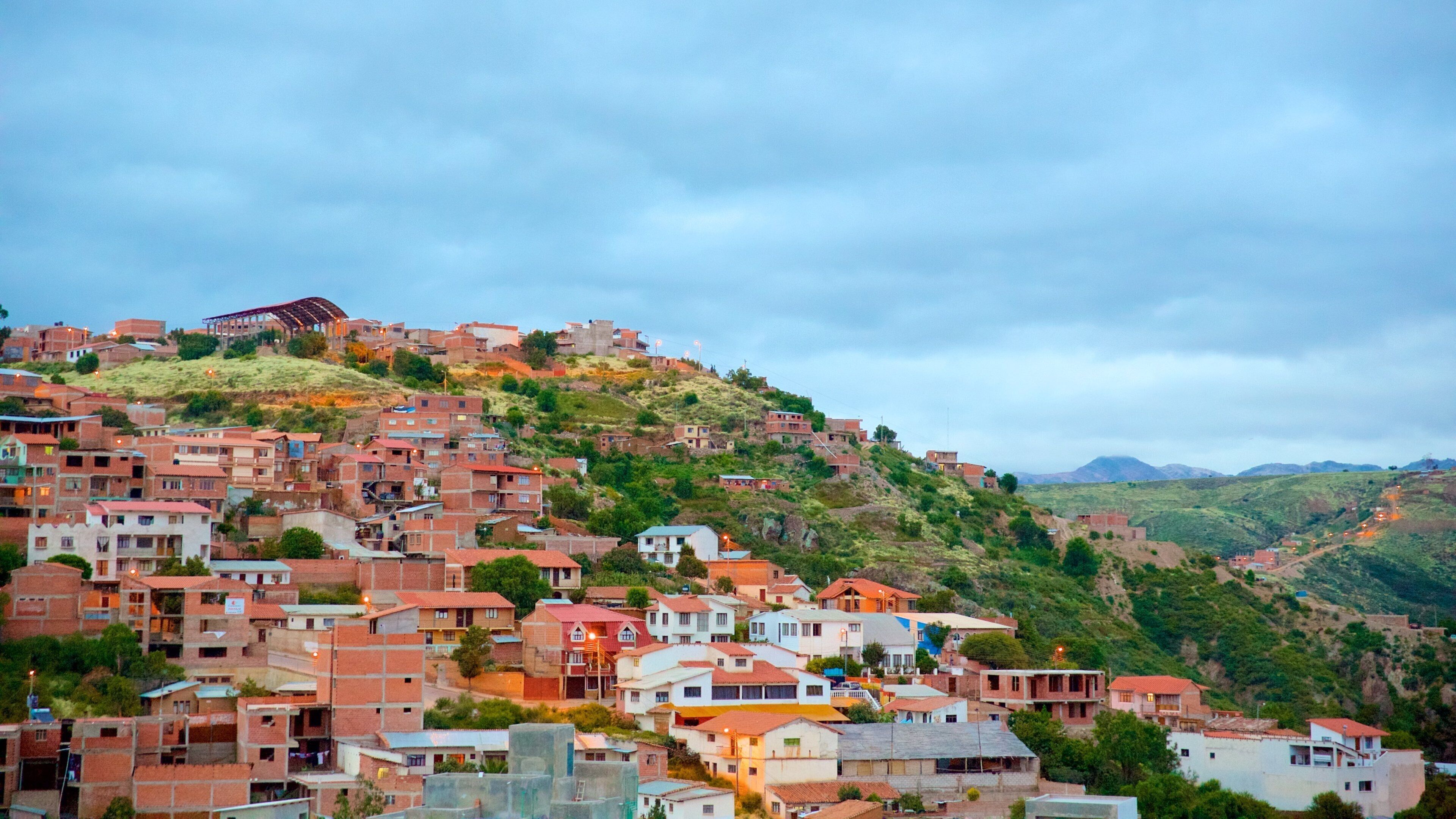 A hillside settlement with densely packed buildings, some with red roofs, and a prominent structure on the hilltop.