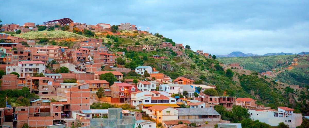 A hillside settlement with densely packed buildings, some with red roofs, and a prominent structure on the hilltop.