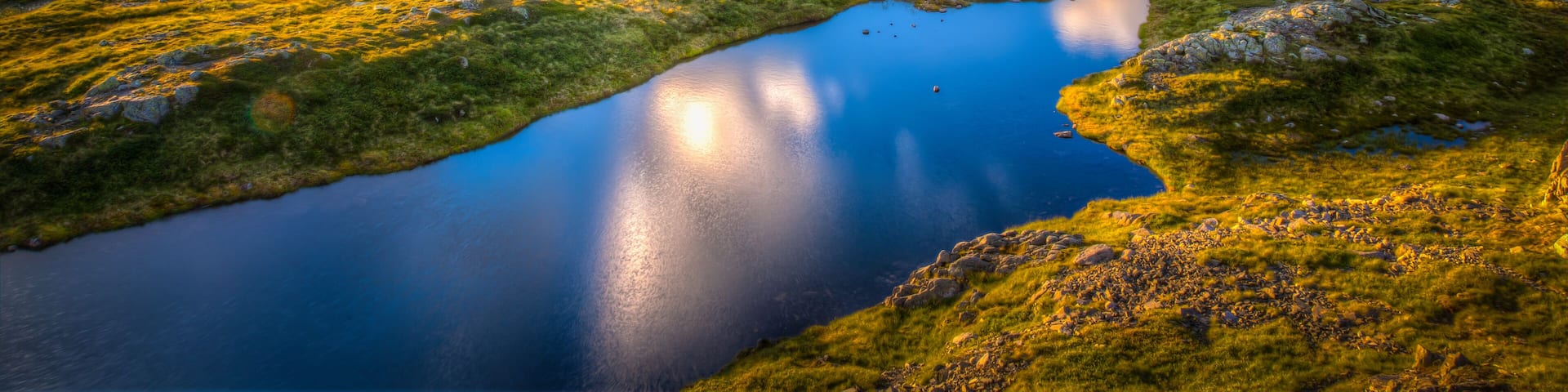 A mountainous landscape with a lake and a river.