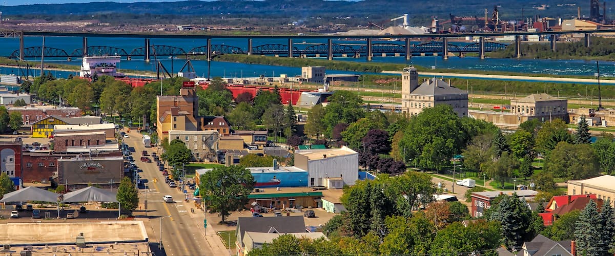A riverside town with a bridge, industrial buildings, and a river.