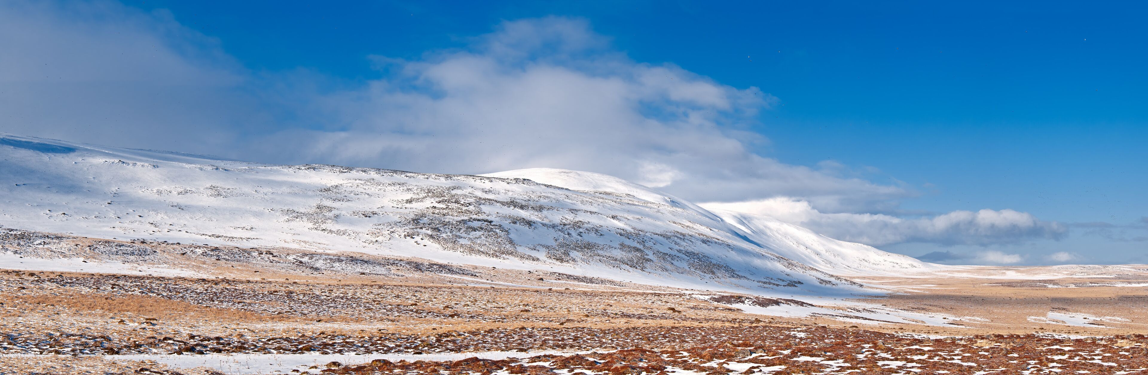 A snow-covered mountain range under a clear blue sky.