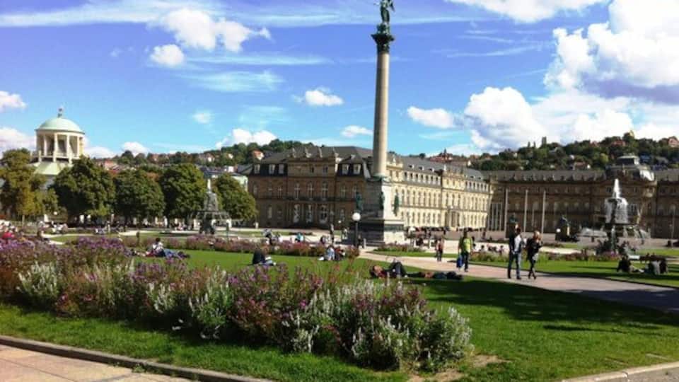 Un parc abritant un monument imposant, un bâtiment en forme de dôme et un grand bâtiment à l’architecture classique.