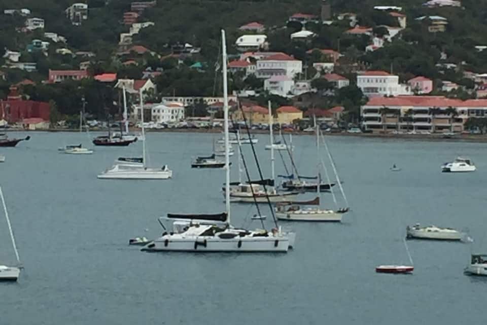 A marina with several sailboats and yachts anchored in calm waters.