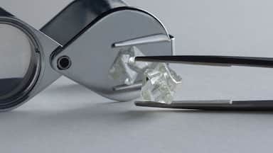 Rough diamond close up in the process of evaluation by diamond expert. High quality photo