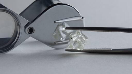 Rough diamond close up in the process of evaluation by diamond expert. High quality photo