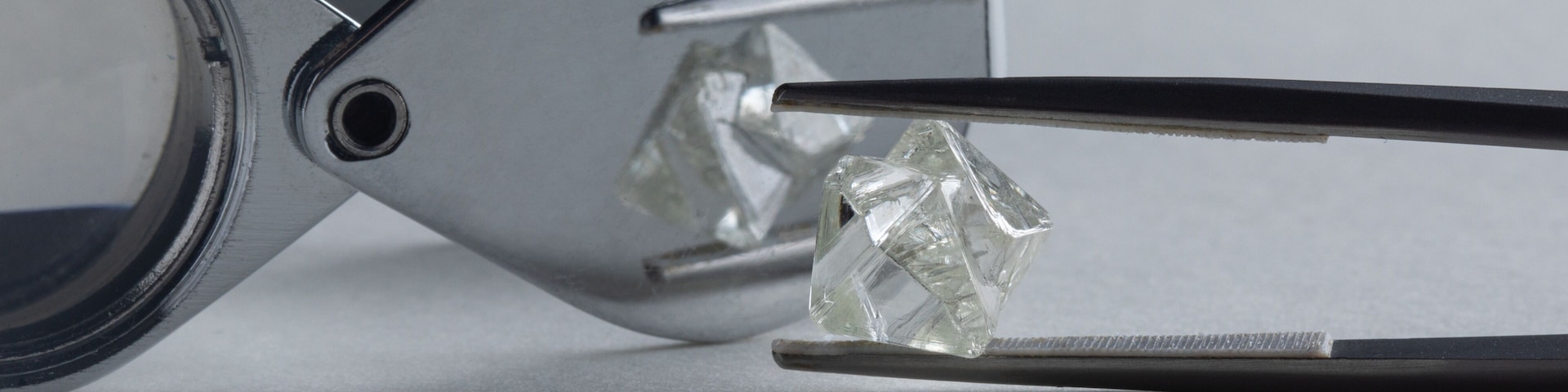 Rough diamond close up in the process of evaluation by diamond expert. High quality photo
