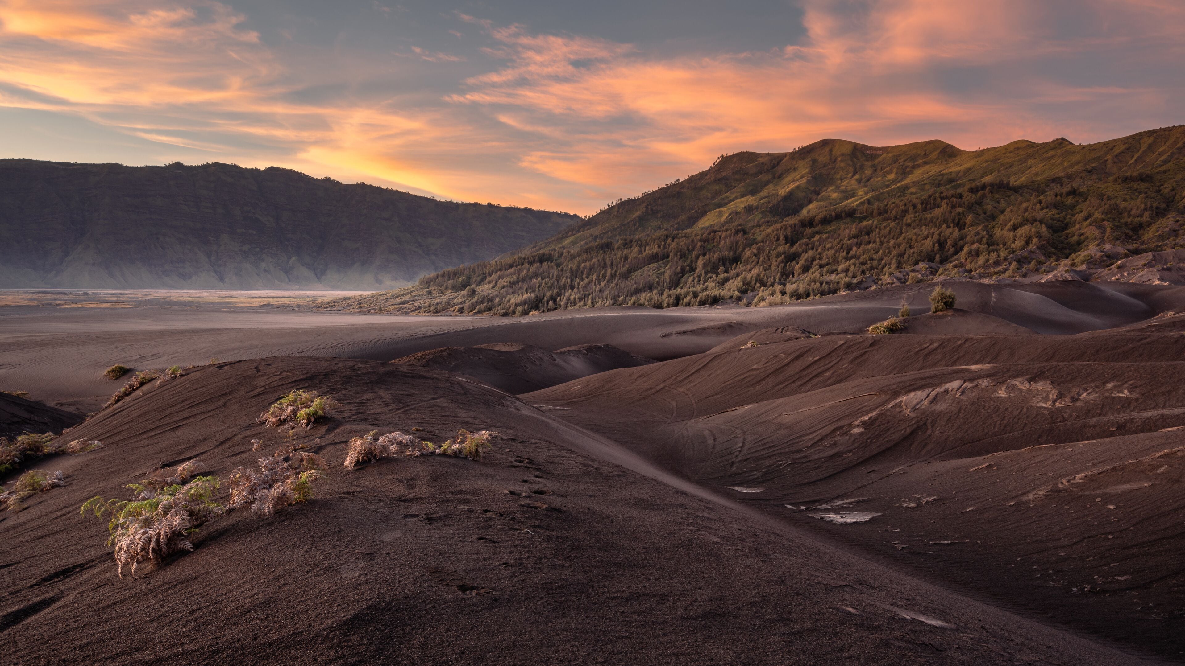 Bromo National Park, East Java, Indonesia - October 16, 2020 : View on the sand sea of Mount Bromo at sunrise with a colorful sky