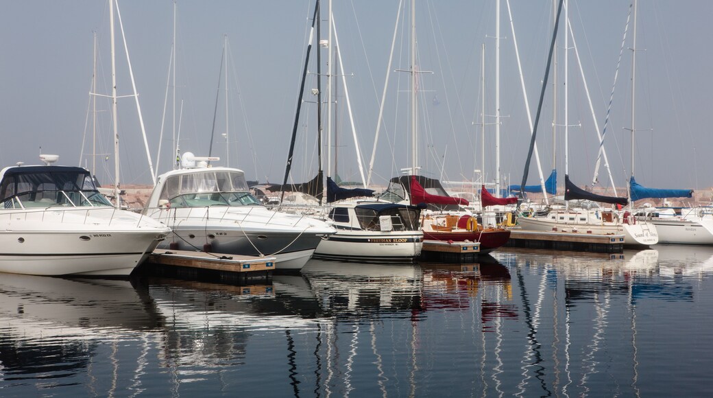 Docked sailboats and power boats cast a reflection on the calm harbor waters of Egg Harbor, Door County, Wisconsin on a late spring morning.
