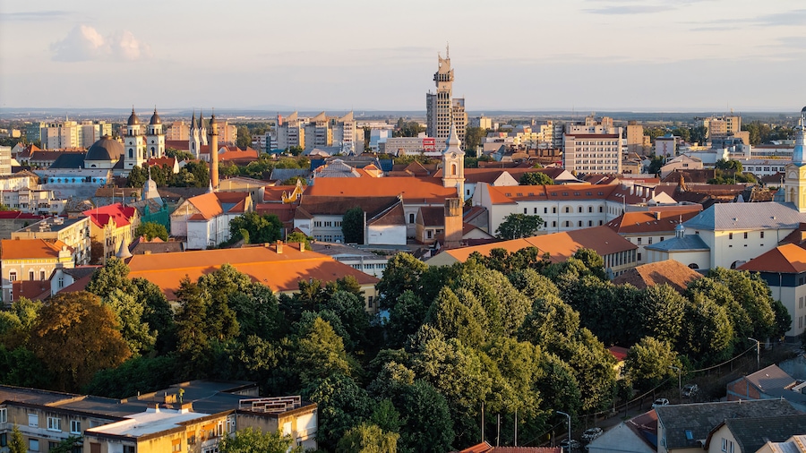 A cityscape with historic buildings, a prominent church tower, and a mix of modern and traditional architecture.