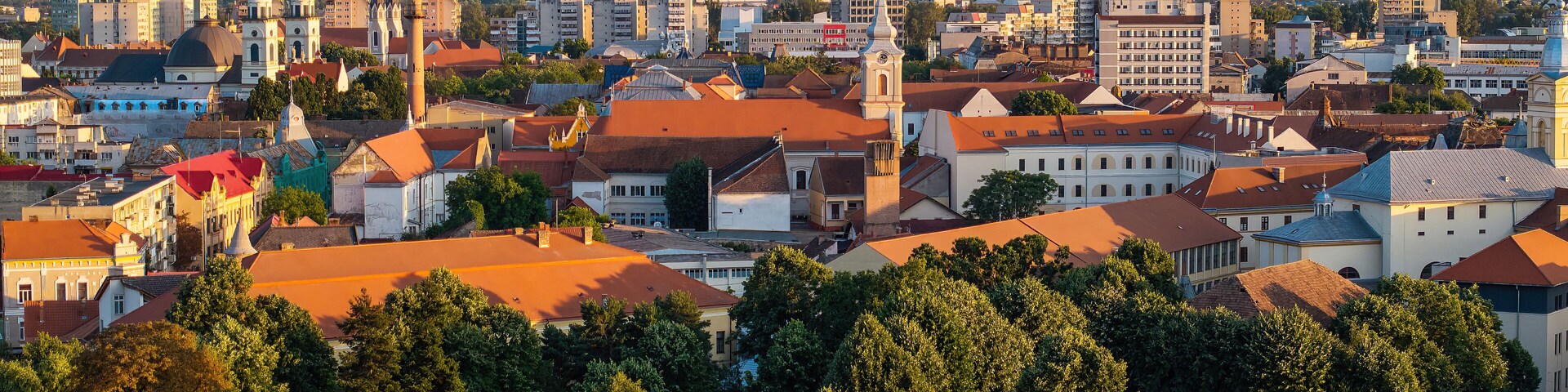 Un paisaje urbano con edificios históricos, una torre de iglesia destacada y una mezcla de arquitectura moderna y tradicional.