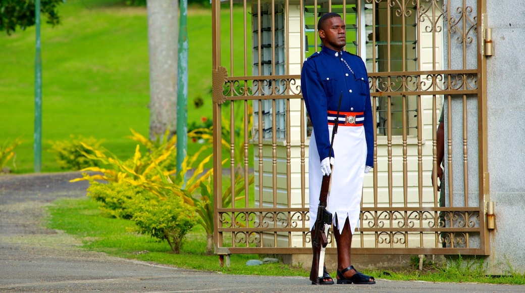 Suva featuring military items and an administrative building as well as an individual male