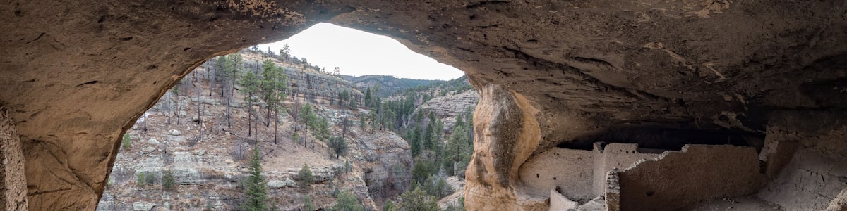 Man exploring cave dwelling at Gila Cliff Dwellings National Monument, Silver City New Mexico