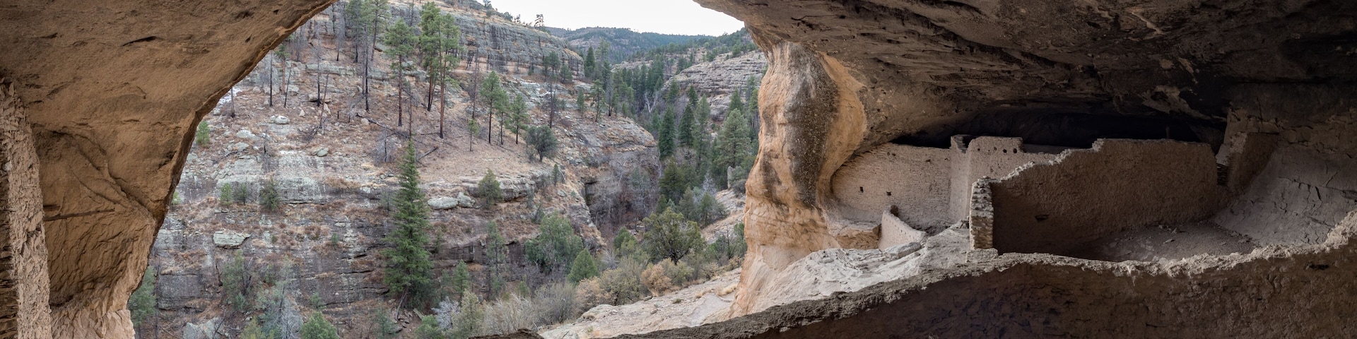 Man exploring cave dwelling at Gila Cliff Dwellings National Monument, Silver City New Mexico