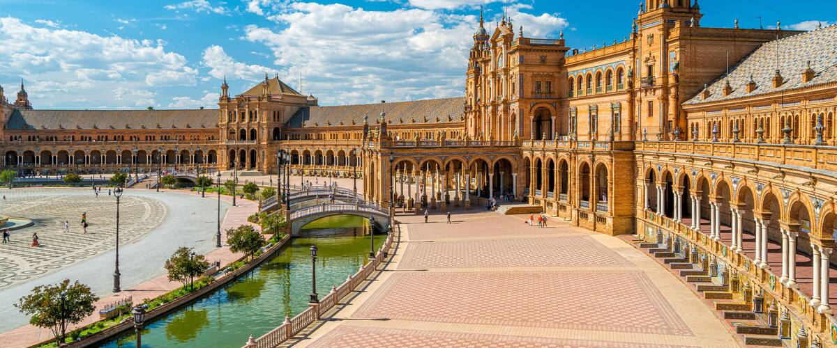 A historic building with a large courtyard, a river, and a bridge.
