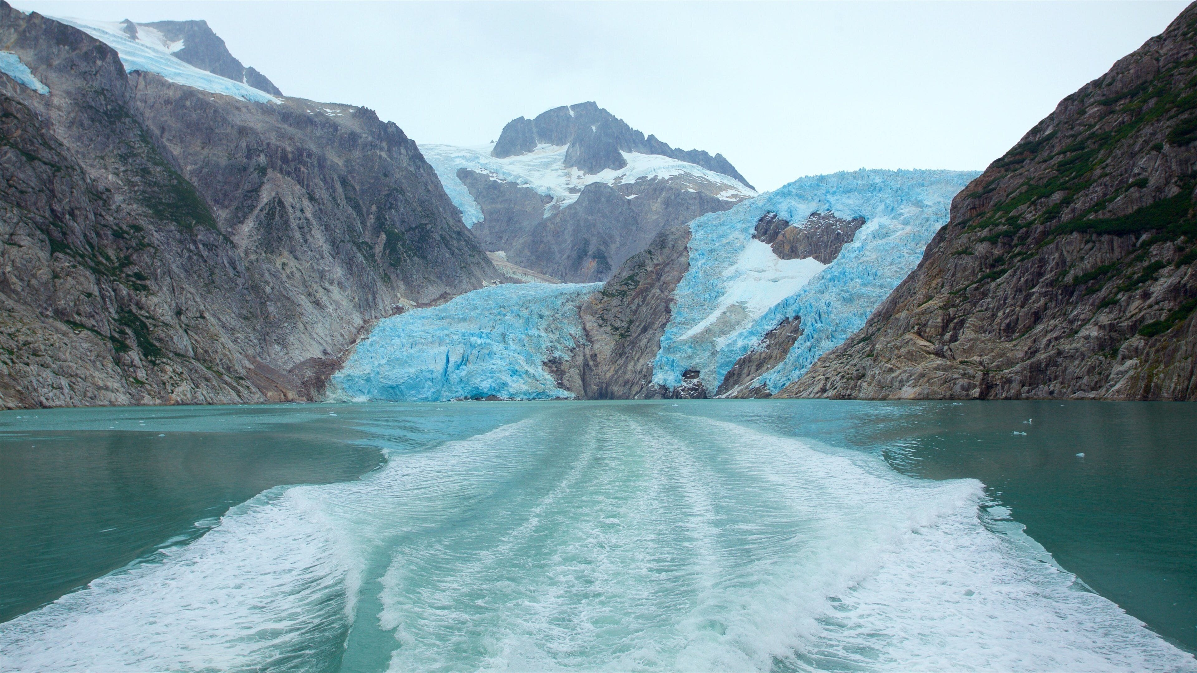 A glacier with a boat in the foreground.