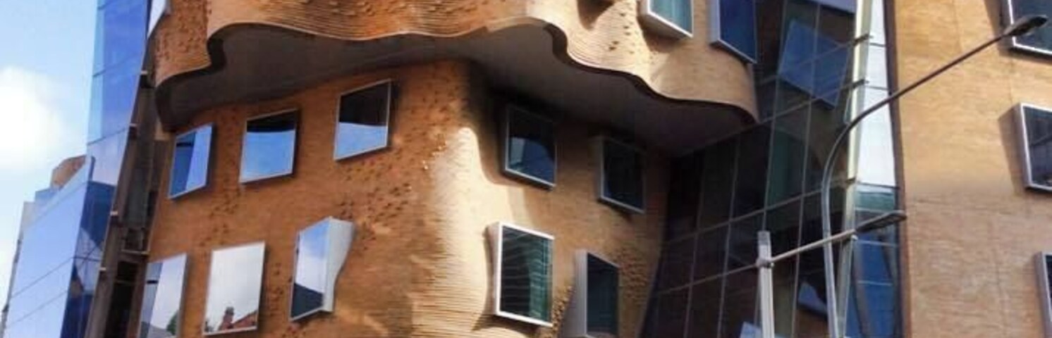 A modern building with a unique wavy facade and multiple windows.