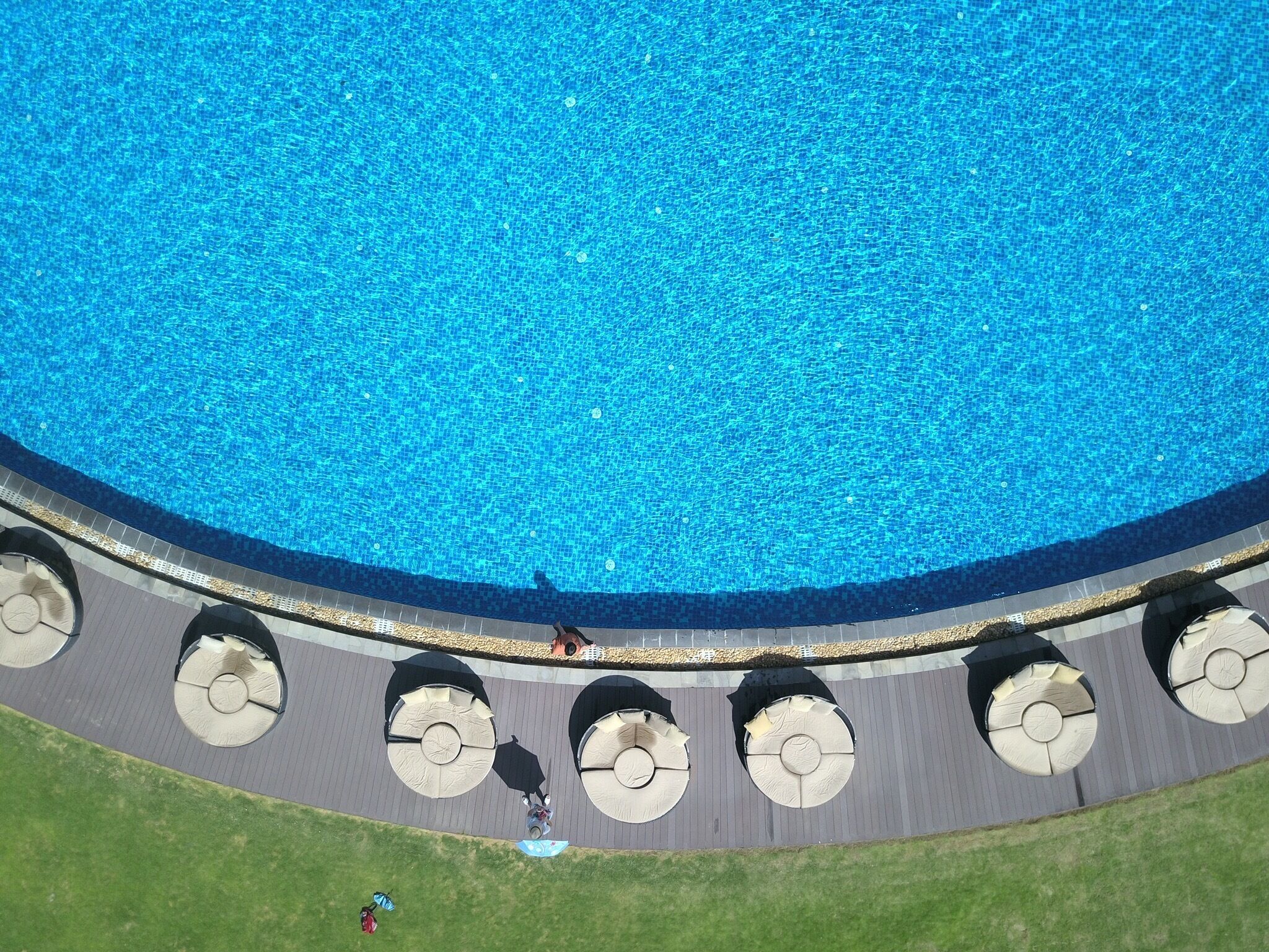 Birdview of swimming pool，it is about 100 meters away from the beach. The sun beam is too strong，no one in it，but some girls is taking photos.