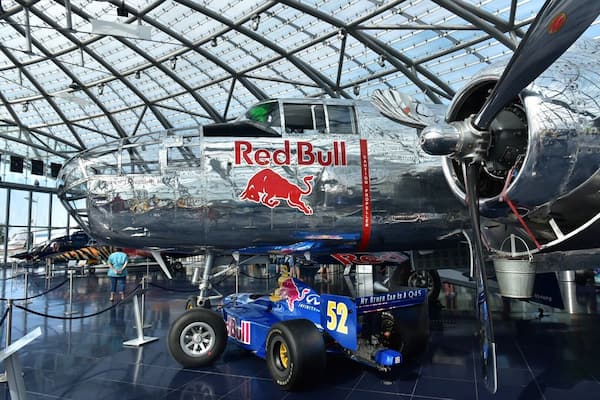 http://www.hangar-7.com/de/
Hangar-7 is a building in Salzburg, Austria, hosting a collection of historical airplanes, helicopters and Formula One racing cars, and serving as home for the Flying Bulls, an Austrian aviation team. Hangar-7 is owned by Red Bull founder Dietrich Mateschitz. It houses the Michelin starred restaurant Ikarus,two bars and a lounge. The building is airfoil shaped, constructed of 1,200 tons of steel and 75,000 sqft of glass surface
