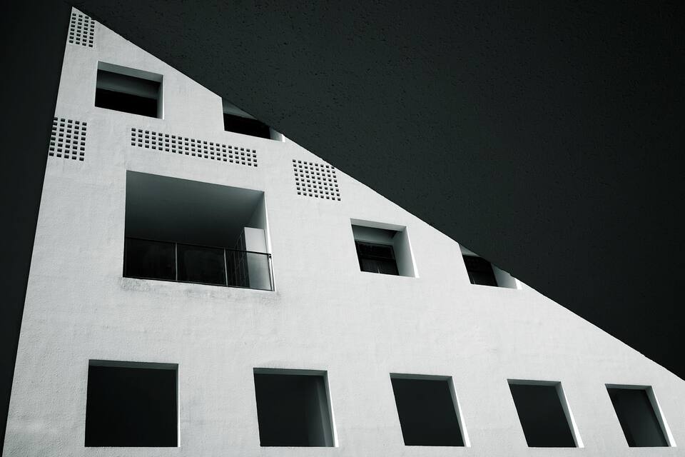 A modern building with geometric shapes and multiple windows.