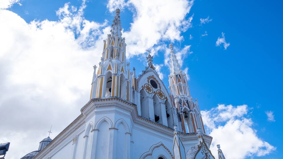 A white church with ornate spires and a clear blue sky.