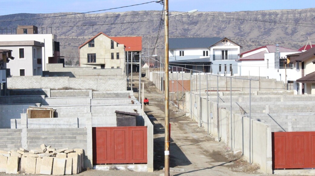 Man in a red shirt, squatting in an alleyway.
View from a new housing development in the city of Tbilisi.