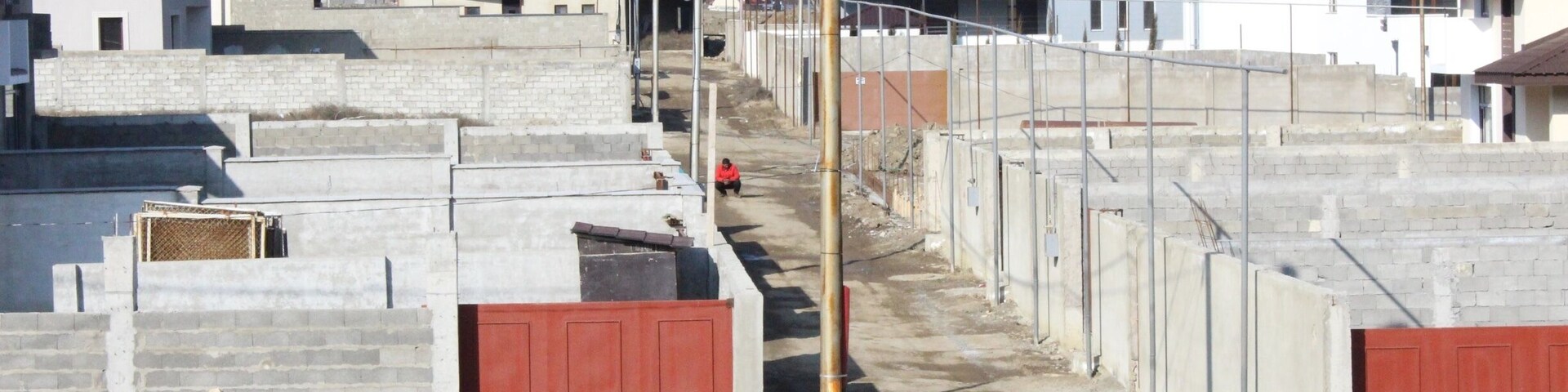 Man in a red shirt, squatting in an alleyway.
View from a new housing development in the city of Tbilisi.