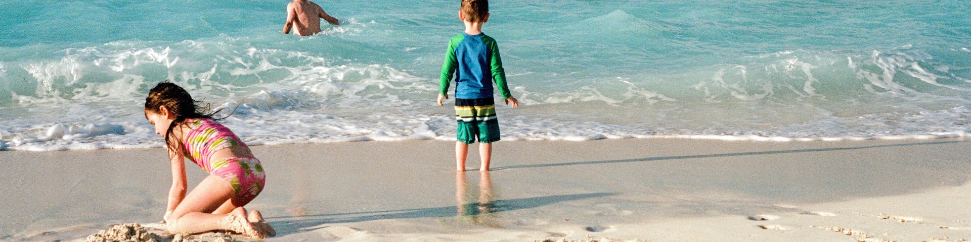 Family Plays Together on Beach While on Vacation in the Bahamas
