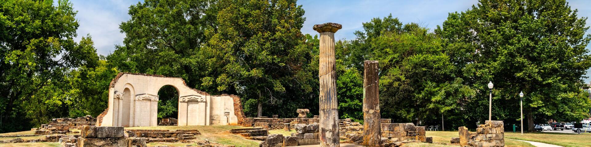Old Alabama State Capitol ruins in Tuscaloosa. Historic site features stone columns and foundation remains in Capitol Park under a blue sky