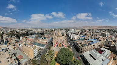 A panoramic view of a city with a prominent cathedral, a mix of modern and traditional buildings, and a clear blue sky.