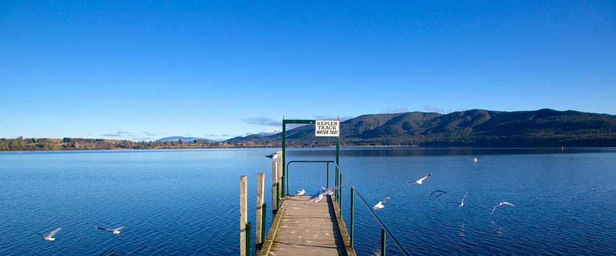 A wooden pier leading to a dock with a sign reading "Kepler Track Water Taxi".
