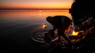 Tezpur, India - November 2020: A woman making an offering with candles on the Brahmaputra River to celebrate Diwali on November 14, 2020 in Tezpur, Assam, India.