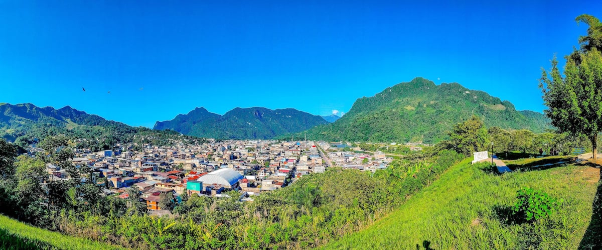 A town nestled in a valley with mountains in the background.