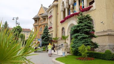 A historic building with ornate architecture, a well-maintained garden, and a clear pathway.