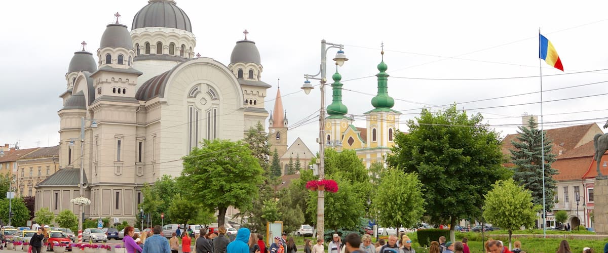 A busy public square with a large cathedral and a smaller church in the background.
