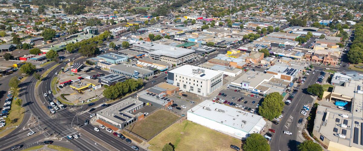 A densely populated urban area with a mix of commercial and residential buildings, a central roundabout, and a large industrial facility.