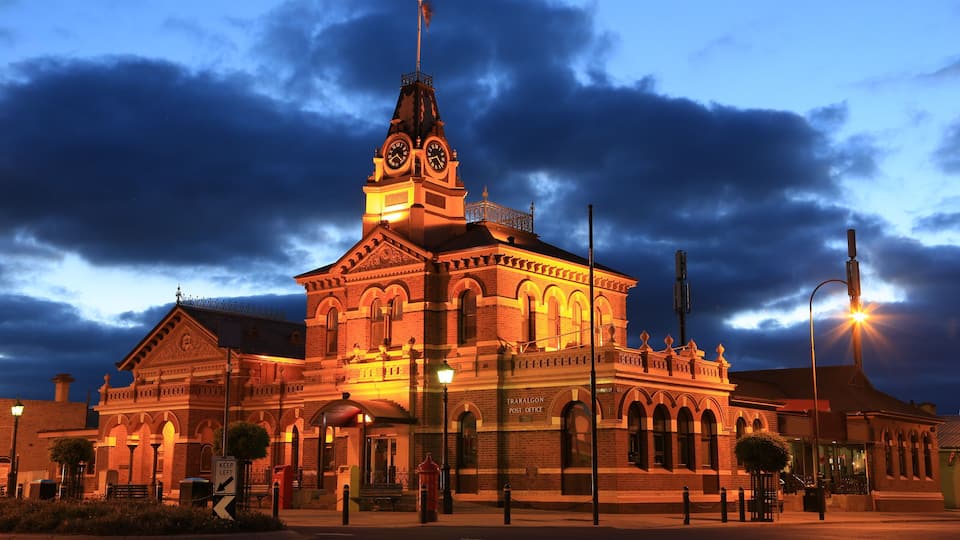 A historic building with a clock tower, arched windows, and a sign reading "Traralgon Post Office."