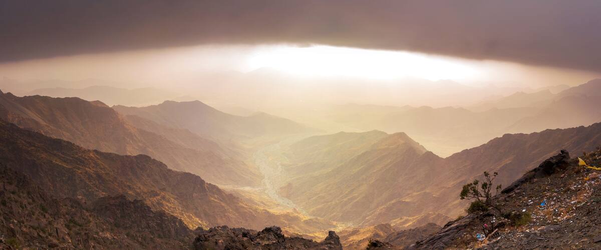A mountainous landscape with a valley and a river.